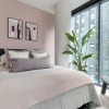 Bedroom with a bed and a large window and table with lamp