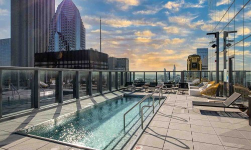 High-rise building amenities featuring a resort-style pool and skyline view