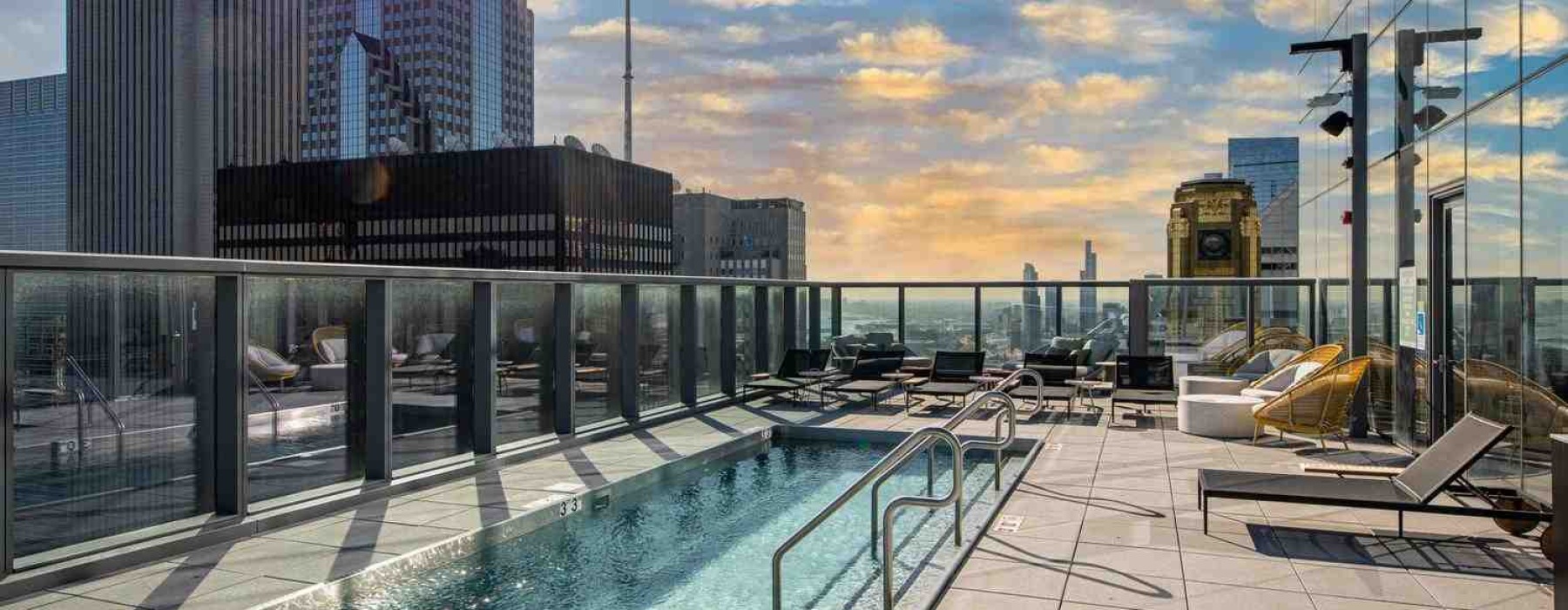 High-rise building amenities featuring a resort-style pool and skyline view